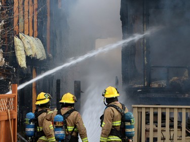 Firefighters extinguish a large fire on Hidden Valley Drive N.W. A home owner shows the emotion of seeing her home damaged by flames in a large fire on Hidden Valley Drive on April 20.