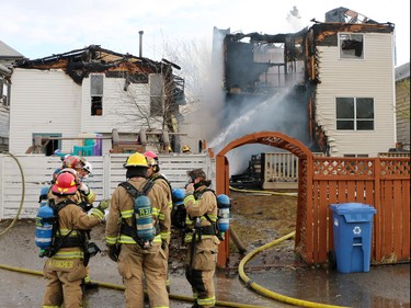 Firefighters extinguish a large fire on Hidden Valley Drive N.W. on Monday, April 20, 2015.
