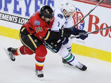 The Vancouver Canucks Dan Hamhuis and the Calgary Flames David Schlemko fight for the puck during third period action of NHL playoff  game 4 action at the Scotiabank Saddledome.