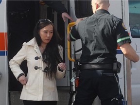 Police escort a woman from an ambulance on Marbank Drive N.E.  The woman had her vehicle stolen at gunpoint at Marlborough Mall and her passenger was later forced out of the vehicle at Marbank Drive N.E. on Wednesday, April 1, 2015.