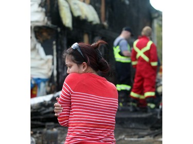 Laarni DeGuzman, a tenant in the upstair unit at 10772 Hidden Valley Drive, looks solemnly at the gutted remains of her life while speaking with fire investigators in the backyard Tuesday April 21, 2015.