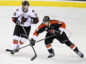 Calgary Hitmen star Adam Tambellini, left, battles Medicine Hat Tiger Markus Eisenschmid during Game 3 on Monday night. The teams resume battle in their second-round Western Hockey League playoff series on Wednesday night in Medicine Hat.