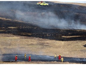 Firefighters control a grass fire on Nose Hill Park in Calgary on April 13, 2015.