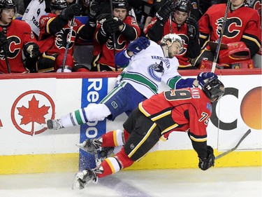 Calgary Flames Michael Ferland, right, collides with  Vancouver Canucks Christopher Tanev during game 6 of the NHL Playoffs at the Scotiabank Saddledome in Calgary.