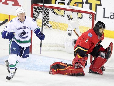 Vancouver Canucks Shawn Mastthias, left, scores on Calgary Flames netminder Jonas Hiller during game 6 of the NHL Playoffs at the Scotiabank Saddledome in Calgary.