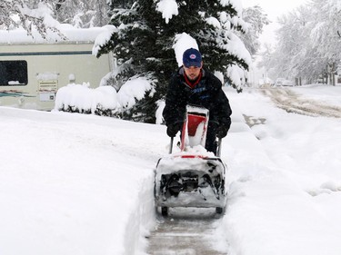 Chris Roy ran out of gas for his snow blower while trying to clean sidewalks in his neighbourhood in Nanton after as much as 40 cm of snow came down over night with more snow coming down on Sunday morning on April 5, 2015.