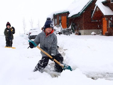 Dason, 9, and Chaydem Clemons, 7, were helping their mom shovel out a deep driveway of snow in Nanton on Sunday morning on April 5, 2015.  What looked like 40 cm of snow fell in Nanton over night with more snow coming down.