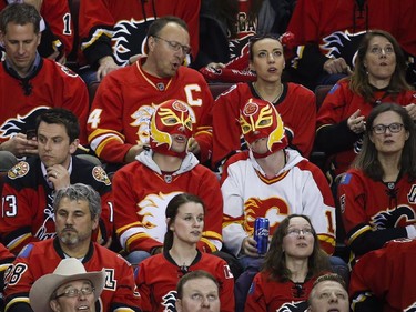 Calgary Flames fans wearing masks watch the scoreboard during the last minutes of third period NHL first round playoff hockey action againat the Vancouver Canucks in Calgary, Tuesday, April 21, 2015.THE CANADIAN PRESS/Jeff McIntosh