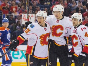 Calgary Flames' Joe Colborne (8), centre, celebrates his goal with Mikael Backlund (11), left, and Kris Russell (4) as Edmonton Oilers' Matt Fraser (28) skates off during first period NHL hockey action in Edmonton, Alta., on Saturday April 4, 2015.