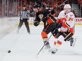 Simon Despres, left, of the Anaheim Ducks sends the puck up ice against Jiri Hudler of the Calgary Flames in Game 1 on Thursday. The Ducks flattened the Flames, who played one of the worst games they've had in weeks.