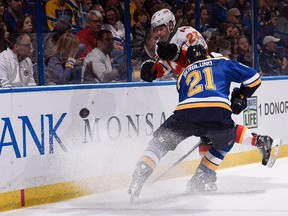 Patrik Berglund of the St. Louis Blues and Sean Monahan of the Calgary Flames pursue a loose puck in Thursday's game. Monahan reached the 30-goal mark for the first time in his career with a tally in the contest.