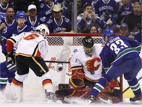 Henrik Sedin #33 of the Vancouver Canucks is stopped by goaltender Jonas Hiller #1 of the Calgary Flames during Game 5 of the Western Conference Quarterfinals during the 2015 NHL Stanley Cup Playoffs at Rogers Arena on April 23, 2015 in Vancouver, B.C, Canada.