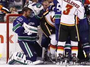 Goaltender Eddie Lack #31 of the Vancouver Canucks pushes Brandon Bollig #25 of the Calgary Flames after making a save against the Flames in Game 2 of the Western Conference Quarterfinals during the 2015 NHL Stanley Cup Playoffs at Rogers Arena on April 17, 2015 in Vancouver, B.C, Canada.