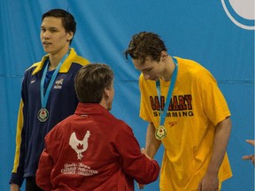 Calgary swimmer Russell Wood, right, gets one of his gold medals at the Canadian Trials in Toronto.