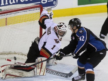 Calgary Hitmen goalie Brendan Burke misses the puck as Kootenay Ice Luke Philp scores in Game 5 Western Hockey League playoff series at the Scotiabank Saddledome in Calgary on April 3, 2015.
