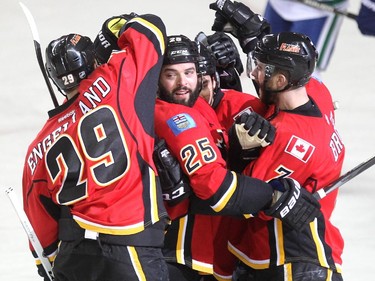 Calgary Flames left winger Brandon Bollig, centre was mobbed by teammates, from left, defenceman Deryk Engelland, centre Josh Jooris and defenceman TJ Brodie after Bollig scored the Flames first goal of the game againsst the Vancouver Canucks during first period NHL Game 3 playoff action at the Scotiabank Saddledome in Calgary on April 19, 2015.