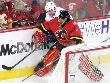 Calgary Flames goalie Jonas Hiller held up Vancouver Canucks right winger Derek Dorsett behind the net during first period NHL Game 3 playoff action at the Scotiabank Saddledome in Calgary on April 19, 2015.