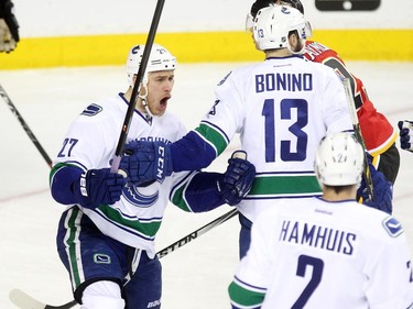 Vancouver Canucks centre Shawn Matthias, left, celebrated after tipping the puck into the Calgary Flames net for the Canucks first goal of the game during first period NHL Game 3 playoff action at the Scotiabank Saddledome in Calgary on April 19, 2015.