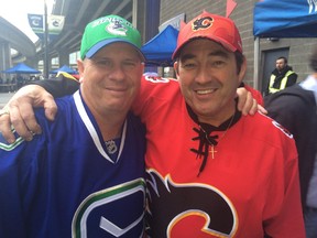 Dean Godal, left, of Vancouver and pal Gary Cater of Calgary get together before the start of Game 5 in Vancouver on Thursday, April 23, 2015.