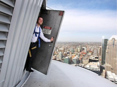 Calgary Tower Controls Specialist Dave Hiemstra peered out a door on the roof of the Calgary Tower on April 21, 2015. Hiemstra is responsible for programming the LED light display show on the Calgary Tower.