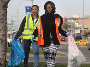 CALGARY, AB.; APRIL 22, 2015   --  Paaly Sok, left, and Tsrha Geberelsa hunt down trash on 17th Avenue SE in the Taking it to the Street Earth Day cleanup Wednesday April 22, 2015. Volunteers fanned out through the neighbourhood in the blitz sponsored by the International Avenue BRZ.  Both are from the Calgary Immigrant Education Society which sent dozens of volunteers. . (Ted Rhodes/Calgary Herald) For City Trax # 00064552A