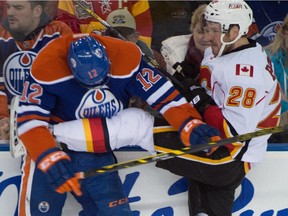 Rob Klinkhammer (12) collides with Corey Potter (28) as the Edmonton Oilers play Calgary Flames at Rexall Place in Edmonton April 4, 2015. The Flames won 4-0.