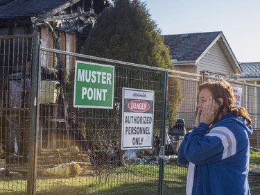 lizabeth Cochrane, is visibly upset after seeing the damage done to her home the morning after a fire destroyed several homes in the community of Erin Woods in Calgary, on April 23, 2015.