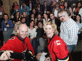 Decked out in Flames jerseys, two of Calgary's best known social media experts, Mike Morrison and Kelly Doody, take selfies at the Social Media Summit on Tuesday, April 28, 2015. They hosted a forum teaching young people the art and skill of being social media gurus of the future.