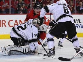 Calgary Flames left winger Michael Ferland, centre, attempts to screen Los Angeles Kings' goalie Jonathan Quick at the Scotiabank Saddledome in Calgary on Thursday, April 9, 2015.