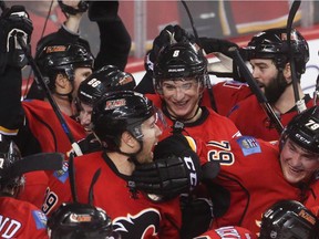 The Calgary Flames celebrate their victory at the Scotiabank Saddledome in Calgary on Thursday, April 9, 2015.