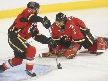 Calgary Flames defenceman Tj Brodie, left, clears the net as Flames goalie Jonas Hiller is found out of position on a Vancouver Canucks attack in Calgary on Saturday, April 25, 2015.
