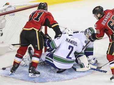Calgary Flames Sam Bennett, right, pokes in his first NHL goal during playoff action against the Vancouver Canucks at the Saddledome in Calgary, on April 19, 2015.