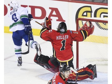 Vancouver Canucks Yannick Webber's skate gets caught in Calgary Flames goalie pad and sends them both flying during game three playoff action at the Saddledome in Calgary, on April 19, 2015.