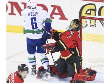 Vancouver Canucks Yannick Webber's skate gets caught in Calgary Flames goalie pad and sends them both flying during game three playoff action at the Saddledome in Calgary, on April 19, 2015.