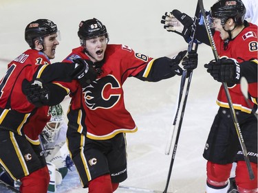 Calgary Flames Sam Bennett, centre, celebrates scoring his first NHL goal with team mates Mikael Backlund, left and Joe Colborne during playoff action against the Vancouver Canucks at the Saddledome in Calgary, on April 19, 2015.