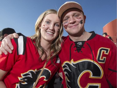 Jeff Waters, right, and Heather McInnis, join the sea of red outside the Saddledome before the Flames first playoff home game in six years in Calgary, on April 19, 2015.