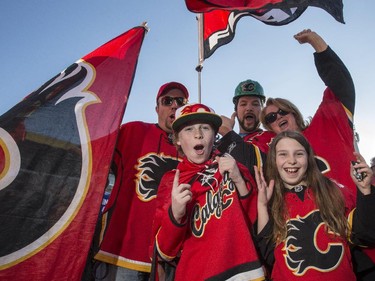 Jeremy Strachen, clockwise from top left, Jared Walker, Sandra Bay, Jordan Bay 15, and Emily Bay, 10, join the sea of red outside the Saddledome before the Flames first playoff home game in six years in Calgary, on April 19, 2015.