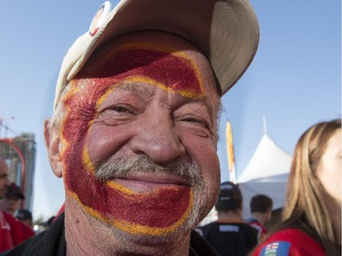 Gordon White stands in line with a flaming C painted on his face before the Flames first playoff home game against the Canucks at the Saddledome in Calgary, on April 19, 2015.