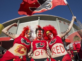 Sarah Grenon, from left, Nicole Grenon, Megan Grenon join the sea of red on the front steps of the Saddledome before the Flames first playoff home game in six years in Calgary, on April 19, 2015.