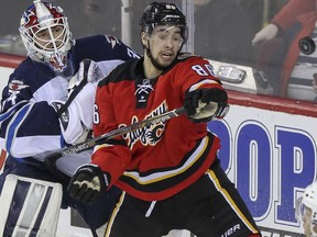 Winnipeg Jets' goalie Michael Hutchinson, left, and Calgary Flames' Josh Jooris watch a loose flying puck during game action at the Saddledome in Calgary, on February 2, 2015.