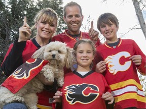 Mel Risdon-Beltcher, left, who help found the name "The Red Mile" back in 2004, poses with her Flames fan family, husband James, top centre, Tanin, 12, right, Bailie, 8, bottom centre, and their pup Scout in Calgary, on April 30, 2015.