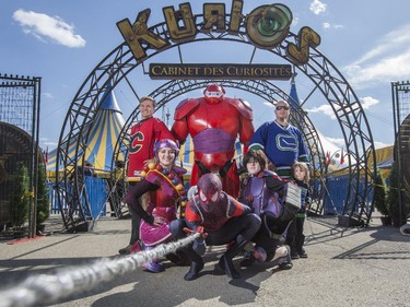 Calgary Flames fan Adam Gladowski poses in his Flames jersey with a curious bunch in front of the Cirque du Soleil Kurios - Cabinet des Curiosités tents, from closewise, with Juan Gallardo dressed as Bay Max, Vancouver Canucks fan Nick Pearson and his son Lukas, 4, Autumn Desjardins dressed as HIro, Devon Nippard as Spider Man, and Emily Lassaline as Honey Lemon, as three iconic events collide on the Stampede grounds in Calgary, on April 19, 2015. Thousands will gather on this one day, in this one place, as Cirque du Soleil, Calgary Comic and Entertainment Expo, and the Calgary Flames first playoff game in six years, all take place on the Stampede grounds.