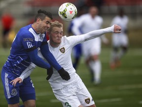 Foothills FC player Kieren Hay, right, collides with an Edmonton opponent during a match at Stampeder Field in Shouldice Park in Calgary on Saturday. Edmonton won 3-1.