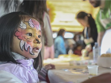 Stephanie Chinprahat waits her turn for a cookie with her beautifully painted face at the Easter Eggstravaganza event at the Calgary Zoo, on April 4, 2015.