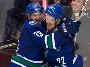 Vancouver Canucks' Henrik Sedin, left and Daniel Sedin have racked up hundreds of points in their NHL careers and combined are near a point a game against the Flames in their careers.