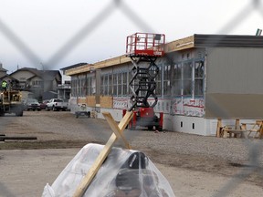 Workers installing 26 portables on Oct. 8, 2013 at Notre Dame Collegiate, in High River.