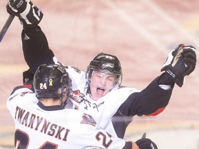 Calgary Hitmen defenceman Travis Sanheim, right, embraces Carsen Twarynski after scoring the double overtime winner that eliminated the Medicine Hat Tigers last Friday at the Scotiabank Saddledome.