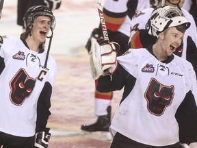Calgary Hitmen captain Kenton Helgesen, left, and goalie Mack Shields cheer after beating the Medicine Hat Tigers 4-3 in overtime on Friday night to clinch their series.