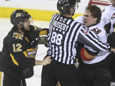 Things get rough between Calgary Hitmen's Elliot Peterson and Brandon Wheat Kings' Reid Gow during WHL playoff action at the Saddledome in Calgary, on April 28, 2015.