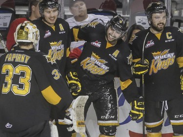 Brandon Wheat Kings' Colton Waltz, 5, laughs and celebrates his empty netter goal which he shot from his end, while being checked into the boards during WHL playoff action against the Calgary Hitmen at the Saddledome in Calgary, on April 29, 2015.